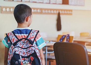 School boy looking for his seat in a classroom