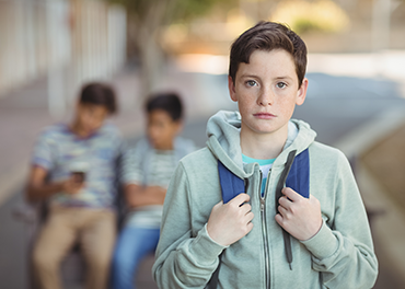 School boy with bag walking in a school