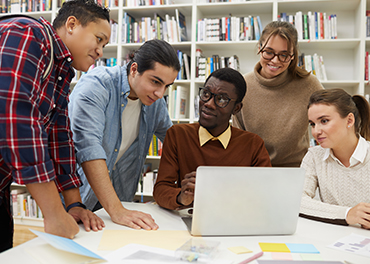 Group of students are leaning in a high school library